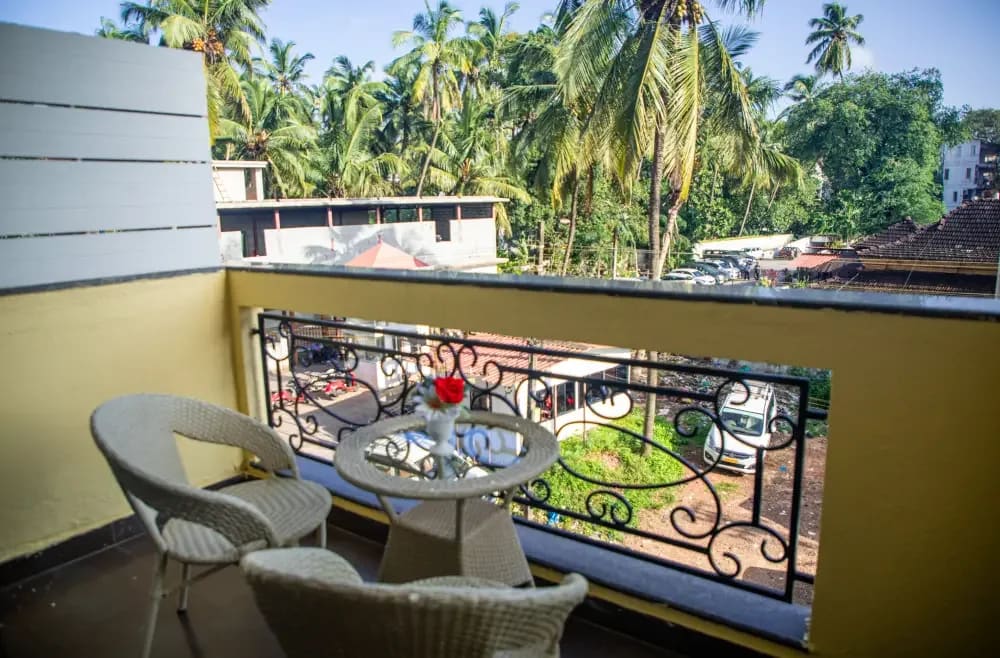 Deluxe City View balcony with table and chairs above the street and palms