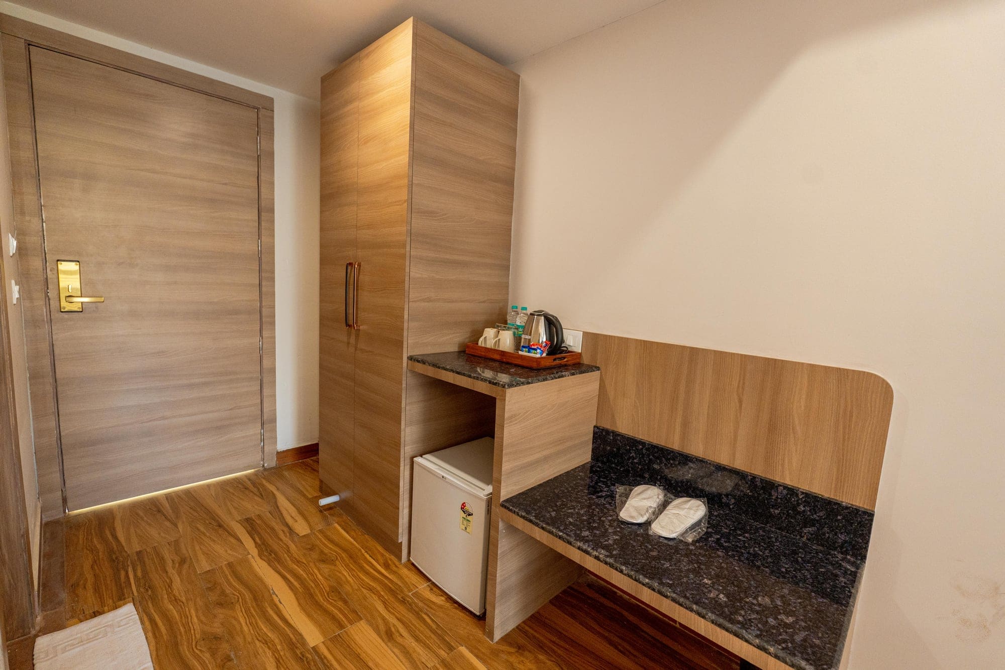 Room entrance with wardrobe, mini bar and tea station