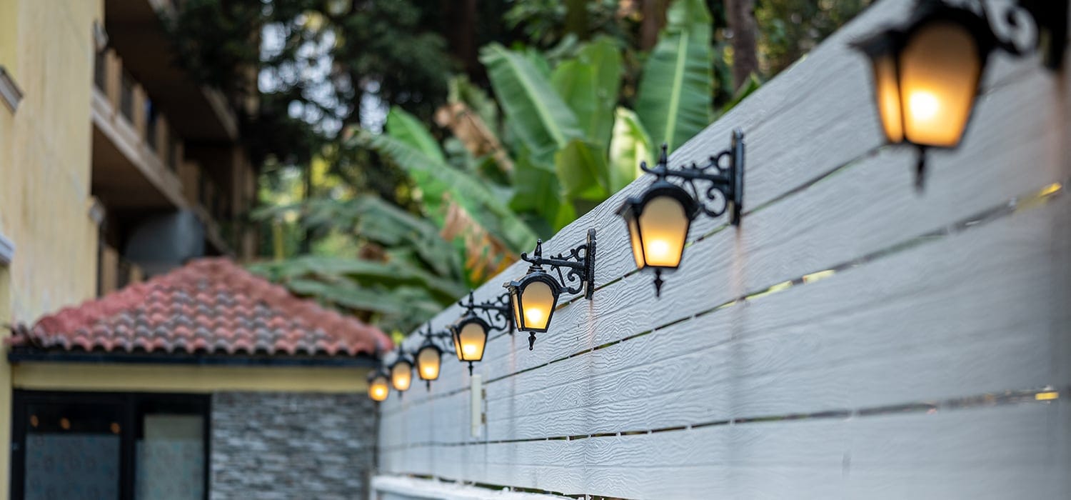 Lanterns along the pool wall at dusk
